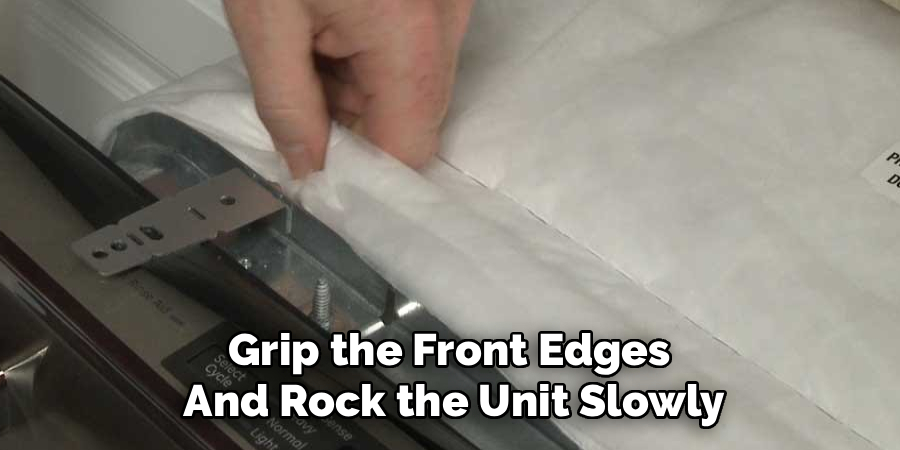 Grip the Front Edges 
And Rock the Unit Slowly