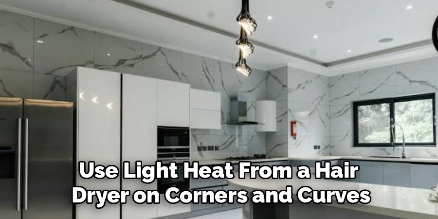 Use Light Heat From a Hair 
Dryer on Corners and Curves